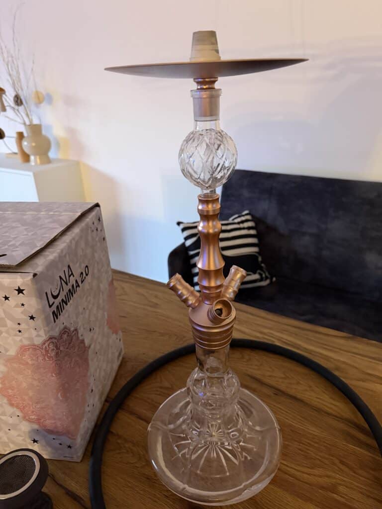 Schöne Shisha mit Glasbowl und Metallteilen auf Holztisch.
