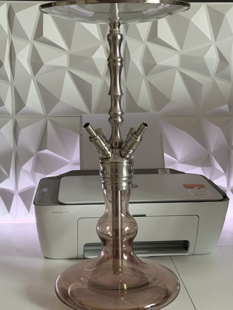 Moderne Shisha mit Metallrohr und Glasbowl auf Schreibtisch.