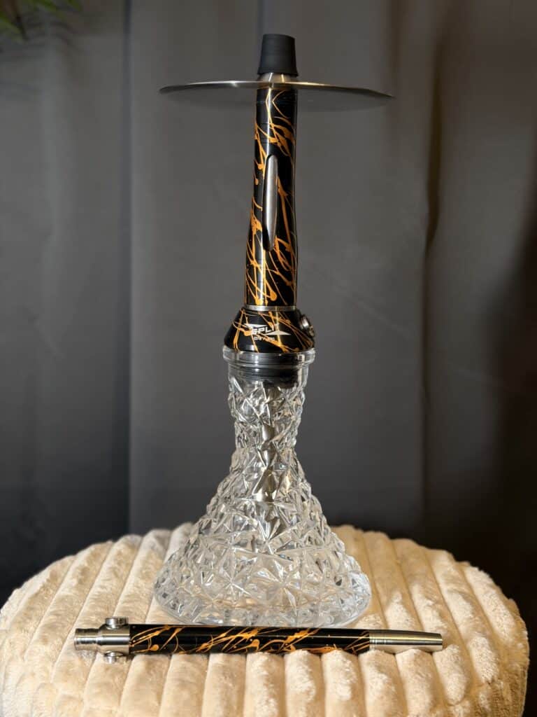 Shisha-Hookah mit dekorativer Glasbowl und Metall-Aufsatz.