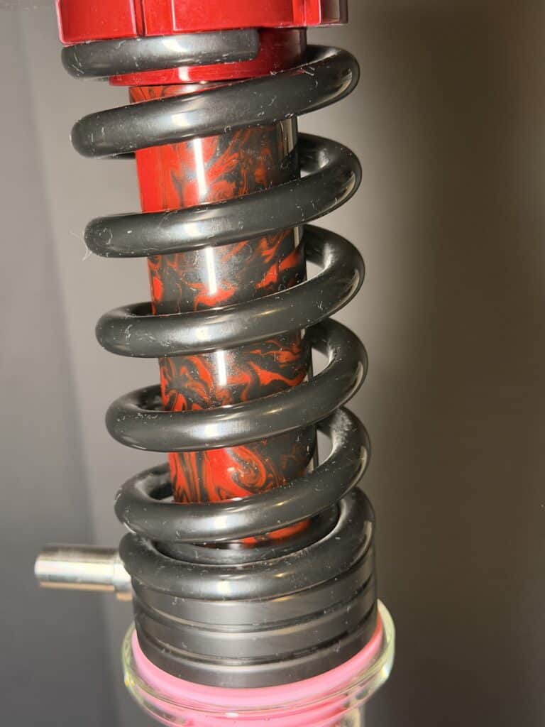 Fahrwerk mit rotem und schwarzem Stoßdämpfer, detailreiche Ansicht.