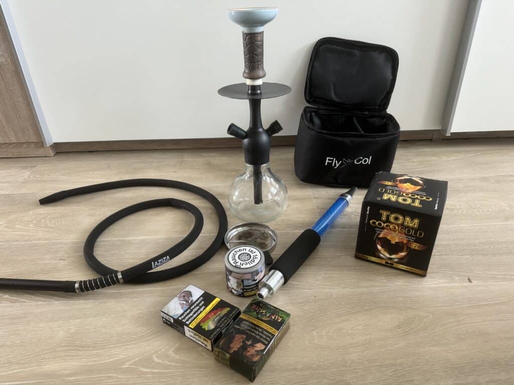 Verschiedene Shisha-Teile und Zubehör auf Boden.