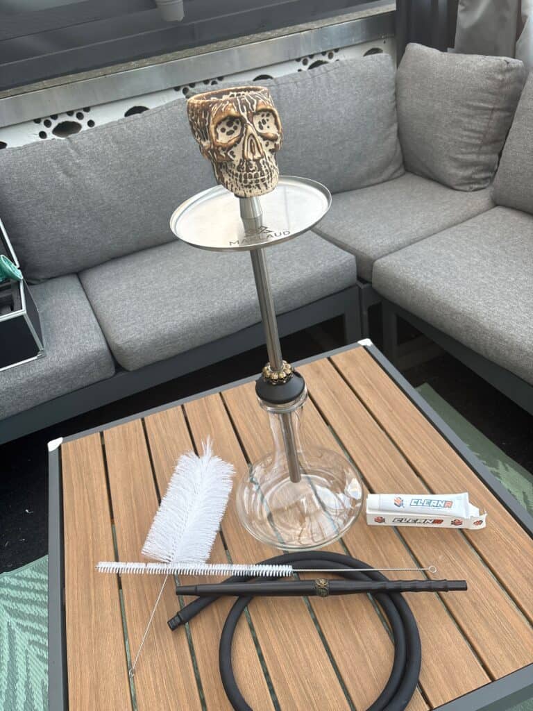 Dekorative Shisha-Glasbowl mit Skull-Motiv auf einem Tisch.