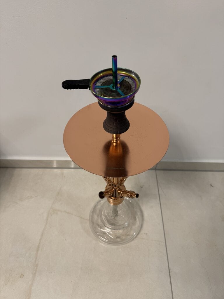 Bunte Glasbowl für Shisha auf einem kleinen Tisch.