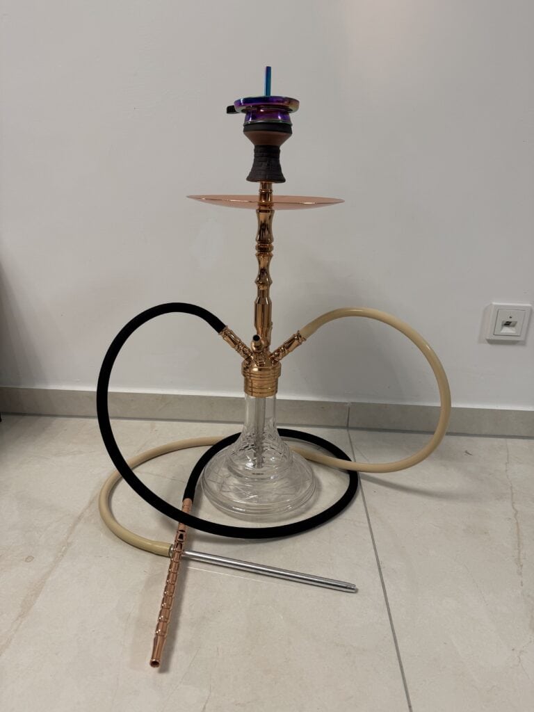 Shisha mit Glasbowl, Schlauch und Kopf auf Boden.