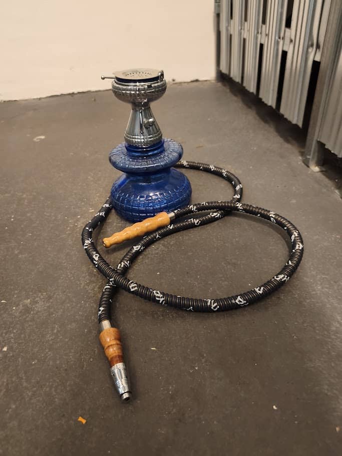 Shisha-Head mit Schlauch und Kopf auf Boden, rauchfrei.