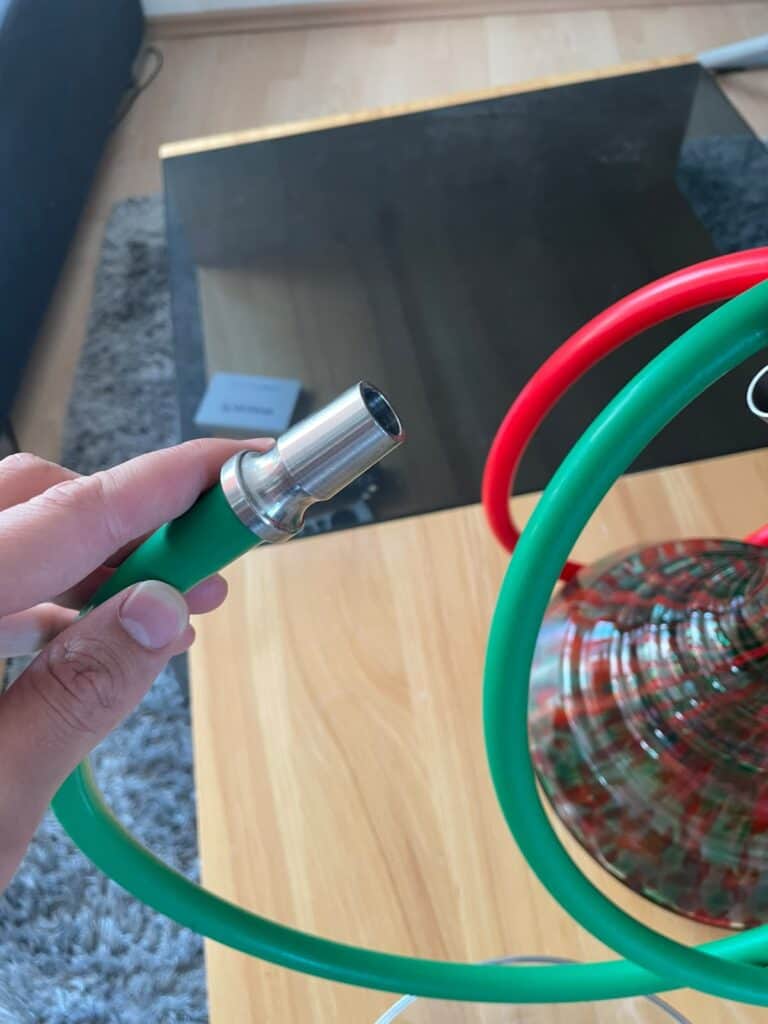 Bunte Shisha mit grüner und roter Schlauch, Glasbowl auf Holztisch.