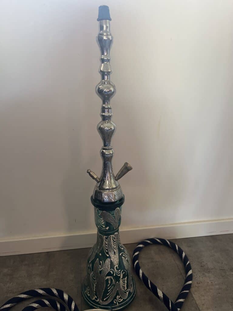 Großer Shisha-Kopf mit Glasbowl und Schlauch auf Boden.
