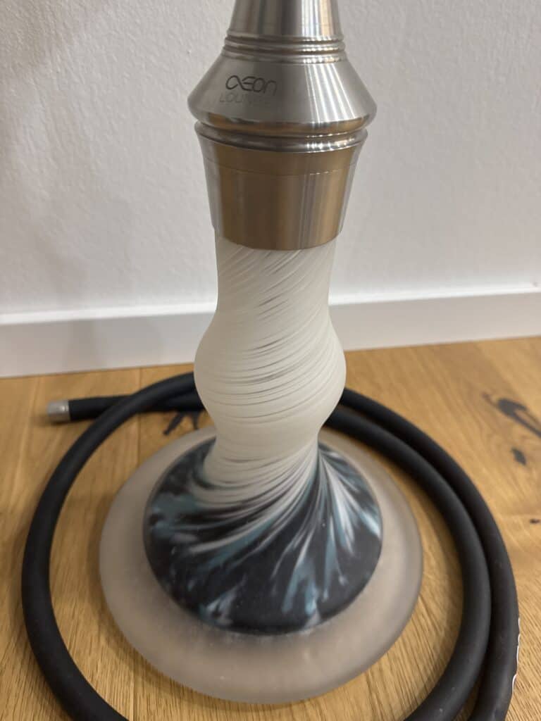 Shisha mit Edelstahlkopf und Glasbowl, auf Holztisch.