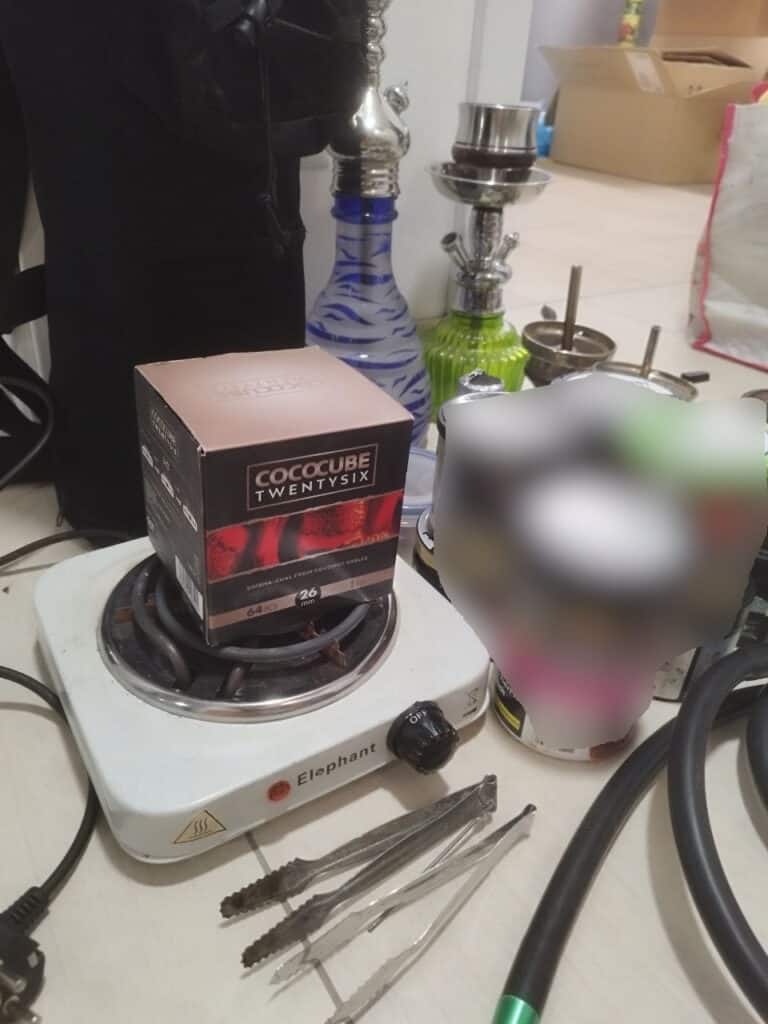 Verschiedene Shisha-Glasbowl und Zubehör auf einem Tisch.