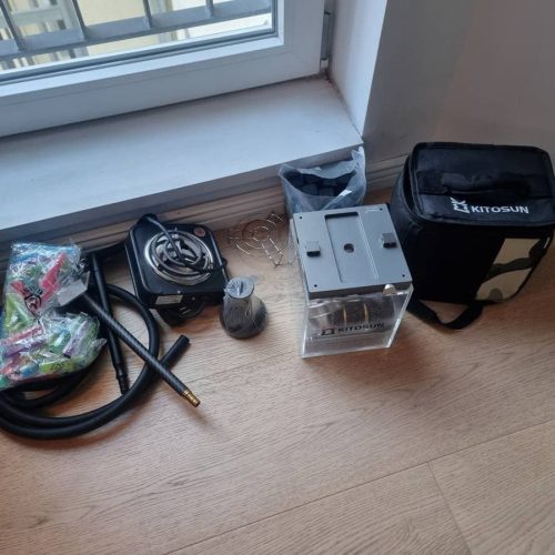 Shisha-Zubehör, Feuerzeug, Schlauch und Kohlebox auf Holzboden.