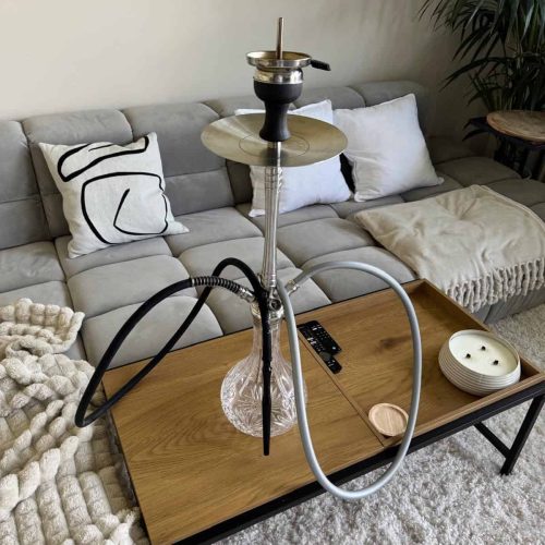 Rauchsäule mit Shisha auf einem Holztisch im Wohnzimmer, bereit zum Rauchen.