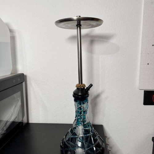 Shisha-Raucherset mit Metallplatte auf Tisch.