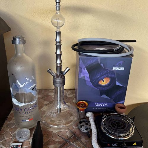 Verschiedene Shisha Teile, inklusive Glasbowl, Heizplatte und Zubehör.
