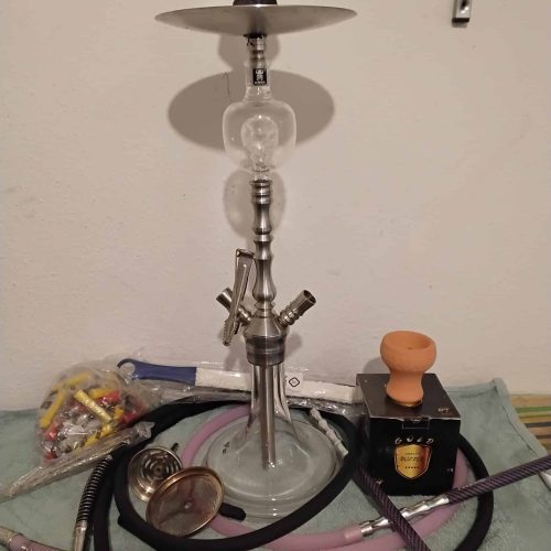 Rauch-Hookah mit Glas, Schläuchen und Zubehör, auf Tisch.
