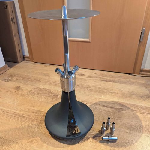 Shisha-Base mit Metalldüse und Zubehör, auf Holzboden.