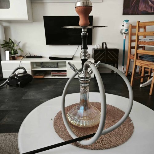 Rauchsäule mit Wasserpfeife auf einem weißen Tisch in modernem Wohnzimmer.