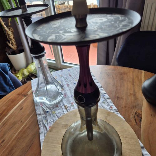 Rauchsäule mit Shisha-Kopf auf einem Holztisch, Wasserpfeife mit Wasser gefüllt, für aromatisches Ra.
