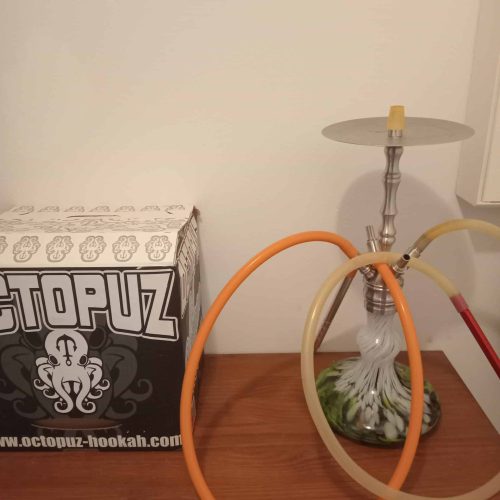 Rauchsäule mit Schläuchen und Verpackung auf Holztisch.