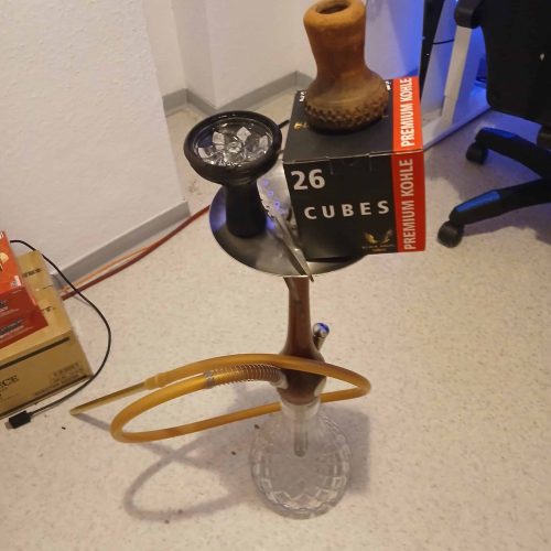 Shisha-Rauchsäule mit Glasaufsatz und Zubehör im Raum.