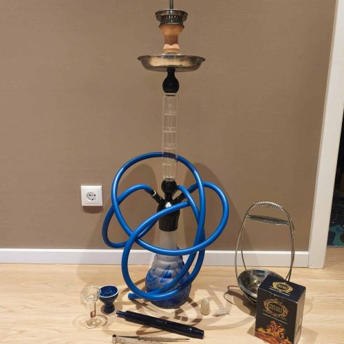 Shisha mit blauer Schlauch, Glasbowl und Zubehör im Raum.