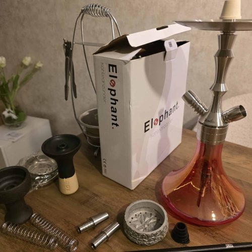 Zubehör für Shisha, inklusive Kohle, Schlauch und Dichtungen, auf einem Holztablett.