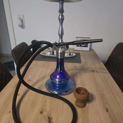 Rauch-Hookah mit Metallaufsatz und Schlauch auf Holztisch.