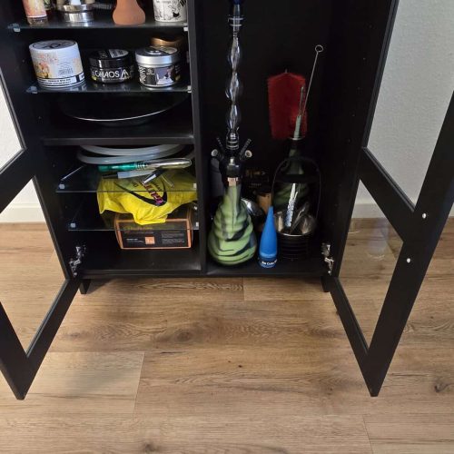 Schwarzer Dampfer- und Zubehörschrank mit verschiedenen Liquids und Zubehör.