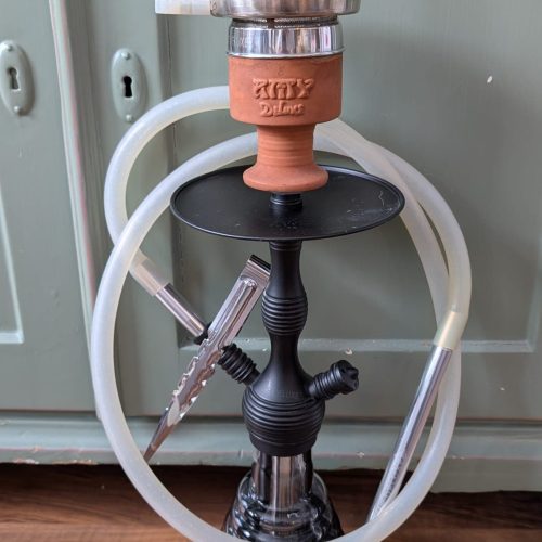 Shisha mit Glasballon, Schlauch und Kopf, bereit zum Rauchen.