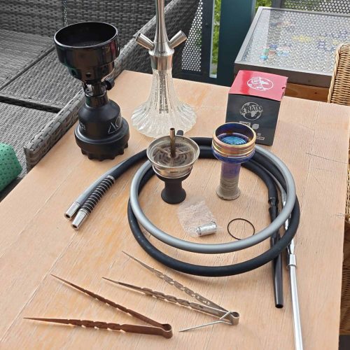Verschiedene Shisha Teile und Zubehör auf Tisch.