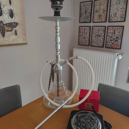 Rauchsäule mit Shisha, Heizplatte und Zubehör auf Esstisch. Perfekt für gemütliche Abende mit Freund.