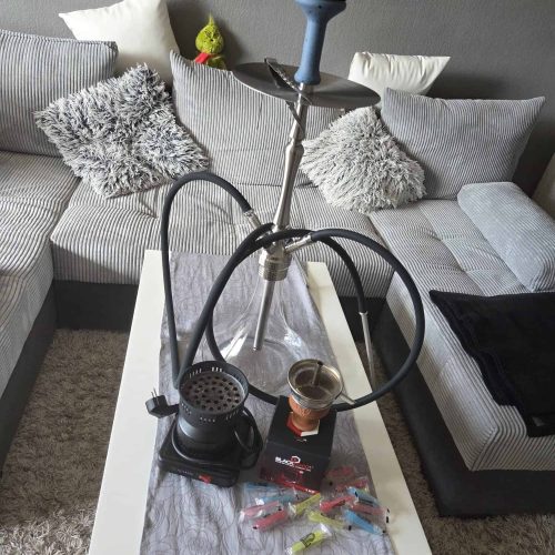 Shisha-Rauchsäule mit Zubehör auf Tisch, Wohnzimmer-Setup.