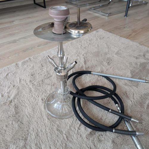 Rauchsäule und Shisha-Zubehör auf einem Teppich im Wohnzimmer.