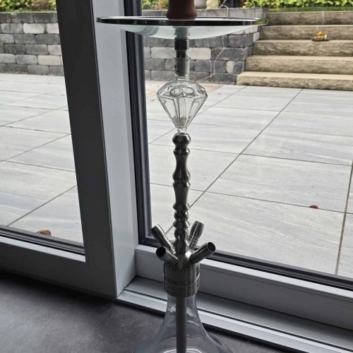 Hochwertige Shisha mit Glasbowl und Holzstücken, im Innenraum.