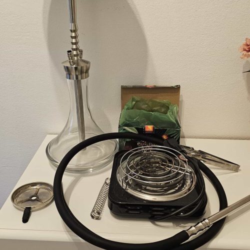 Rauchsäule und Shisha-Zubehör auf einem weißen Nachttisch.