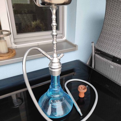 Shisha mit blauer Glasbasis und Metallaufsatz, bereit zum Rauchen.