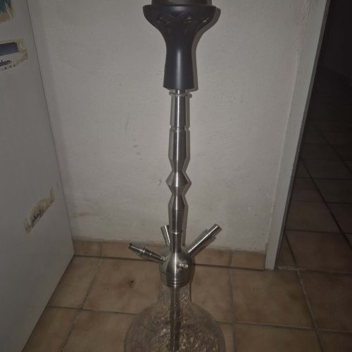 Shisha-Zubehör mit Kopf, Schlauch und Glasbowl auf Boden.