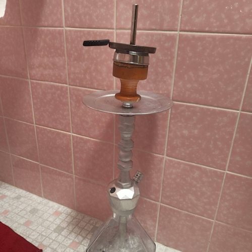 Rauchsäule mit Shisha-Kopf, Glasbasis und Metallrohr, ideal für Wasserpfeifen.