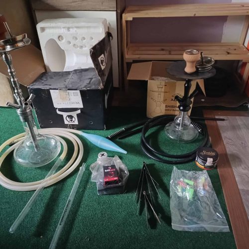 Shisha-Zubehör mit Gläsern, Schläuchen und Tabak, bereit zum Gebrauch.