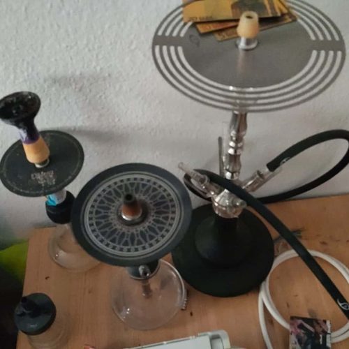 Verschiedene Shisha-Teile und Zubehör auf einem Tisch.