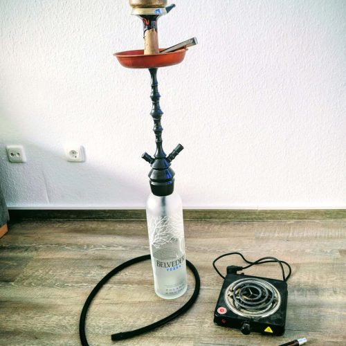 Shisha mit Heizgerät und Rauchsäule auf Boden, Indoor.