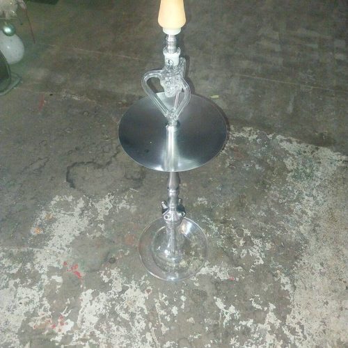 Moderne Shisha mit Glas und Holzgriff, auf Betonboden.