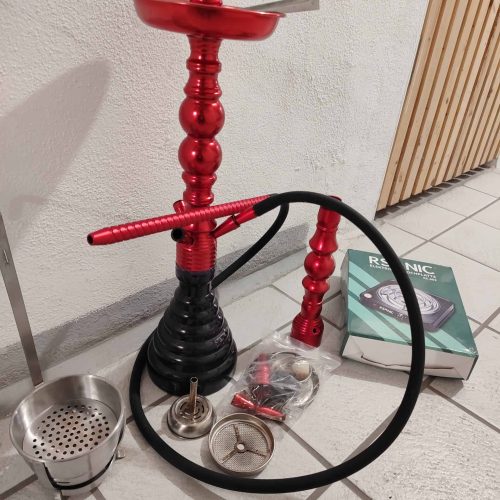 Shisha mit rotem Kopf, Schlauch und Zubehör, bereit zum Rauchen.