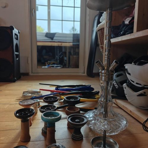 Shisha Glasbowl und Ersatzteile auf Holztisch.
