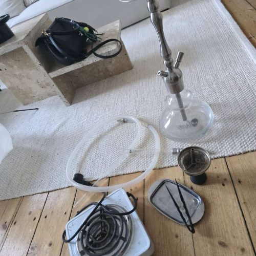 Shisha mit Glasbowl, Schlauch und Kohleofen, ideal für Raucherliebhaber.