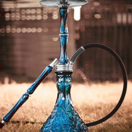 Bunte Glas-Shisha mit Silikonschlauch auf Rasen im Freien.