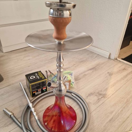 Shisha mit Glasbowl, Metallhülle und Schlauch, bereit zum Rauchen.