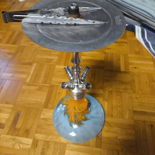 Shisha-Kopf mit Metallzubehör auf einem Wasserpfeifen-Stand.
