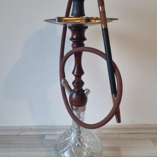 Alte Shisha mit Glasbowl und Schlauch auf Boden.