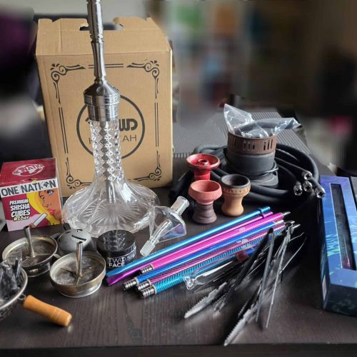 Verschiedene Shisha-Teile, Tabak und Zubehör auf Tisch.