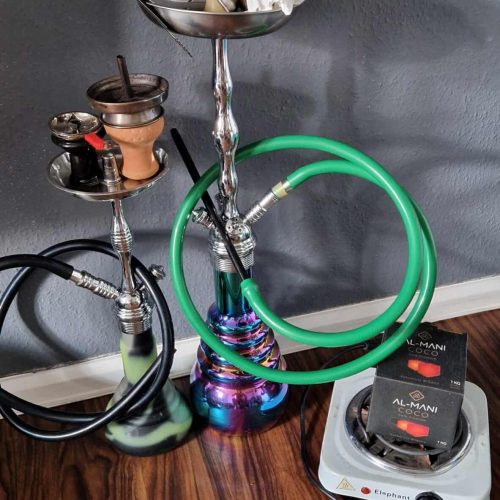 Shisha mit Glasbowl, Schlauch und Kohle auf Holzoberfläche.
